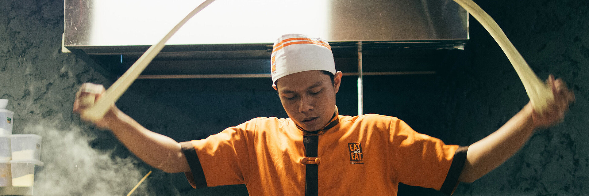 [Translate to Global Deutsch:] Asian cook with embroidered working shirt