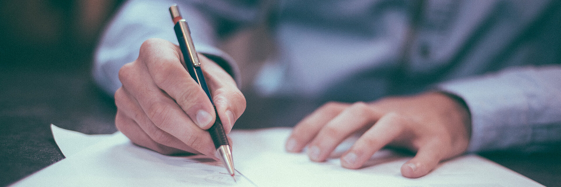 [Translate to Englisch IND:] Businessman writing on a paper