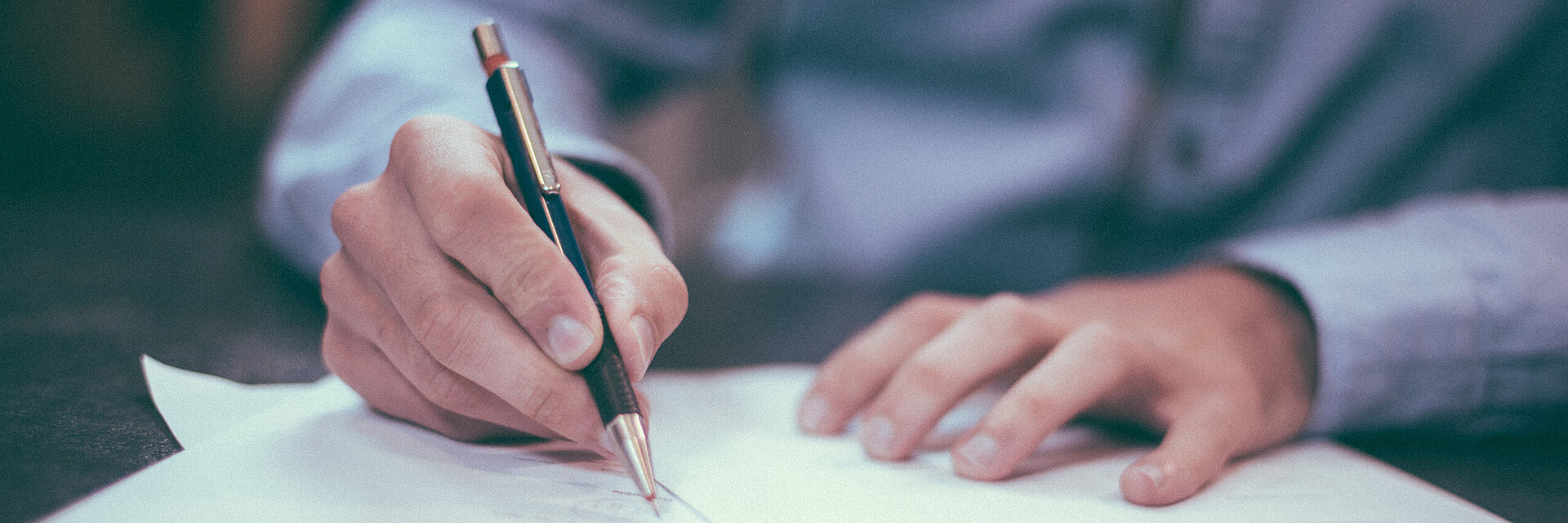 [Translate to Global Französisch:] Businessman writing on a paper