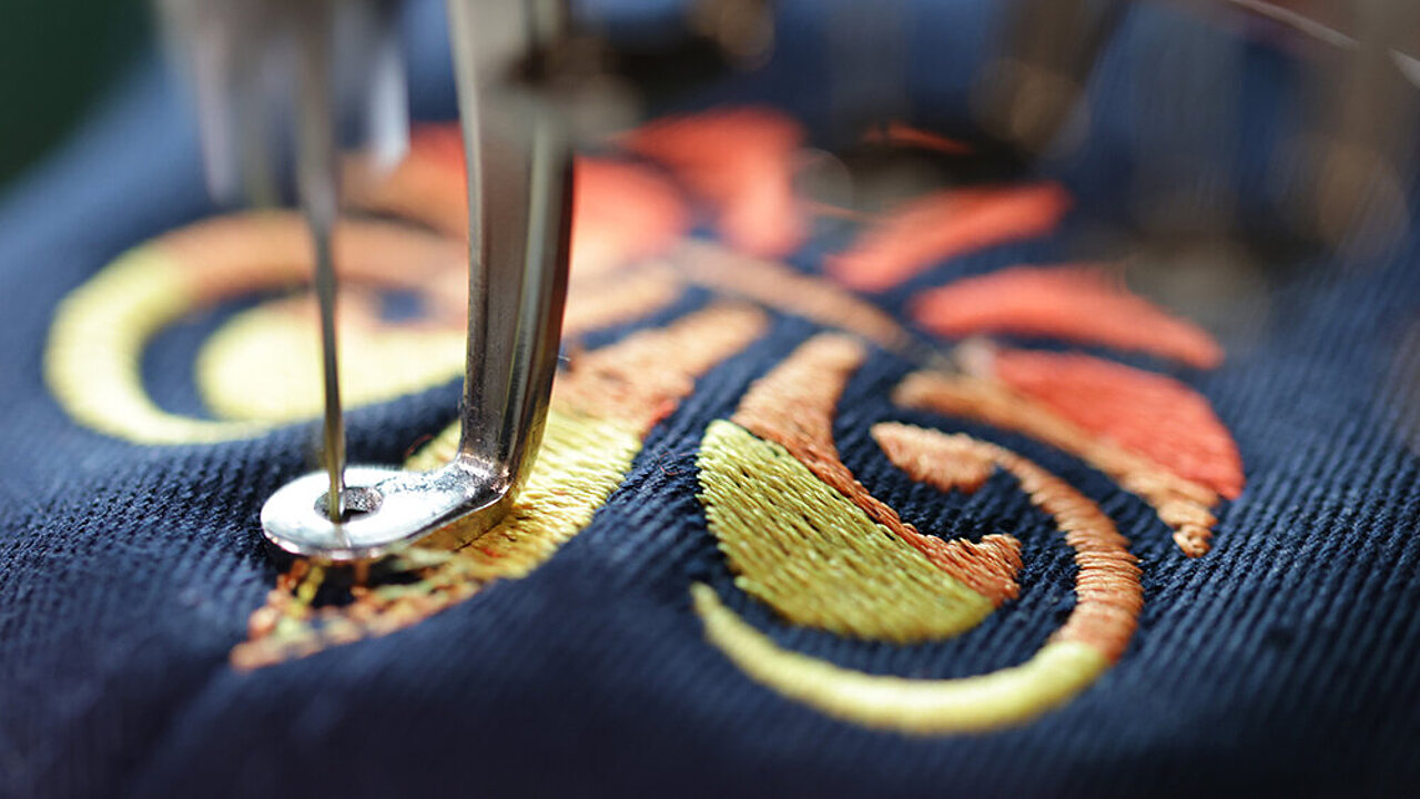 Madeira Coloreel embroidery thread stitching a yellow and red lily design