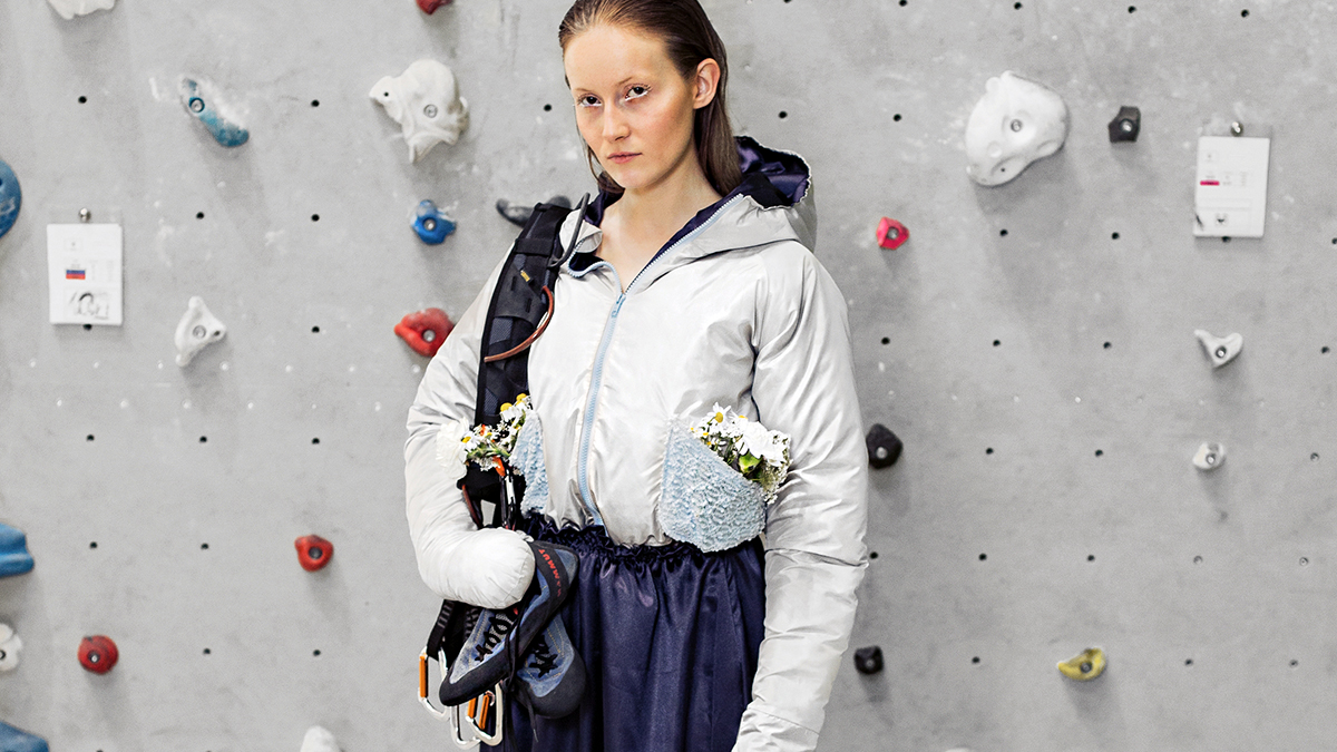 [Translate to Global Portugiesisch:] Girl in embroidered outdoor fashion clothes in front of hiking wall