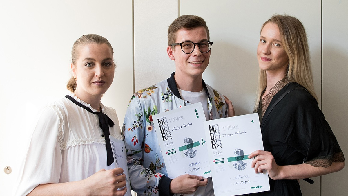 La foto ganadora muestra a los 3 ganadores del concurso. Levantan su certificado con satisfacción.